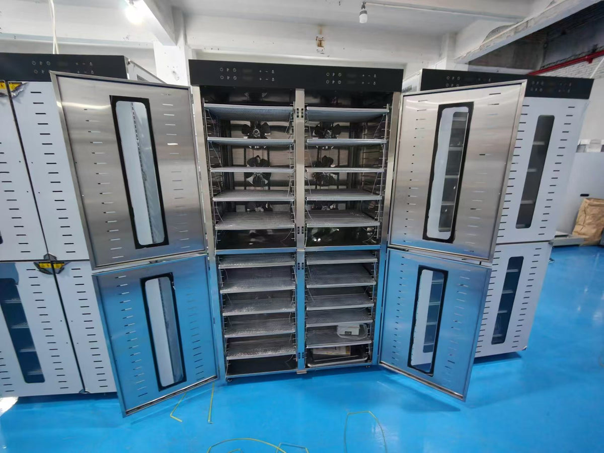 Stainless steel food dehydrators in the manufacturing facility with doors open showing internal drying racks
