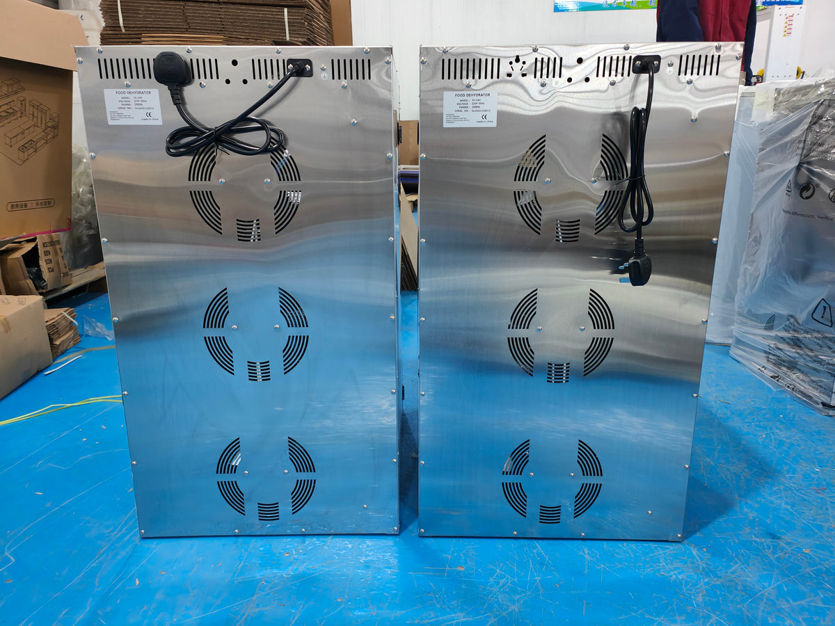 Rear view of stainless steel food dehydrators showing ventilation openings and power cables