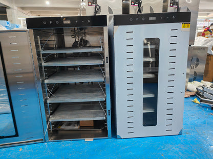 Stainless steel food dehydrator in the factory with open door showing internal wire drying trays