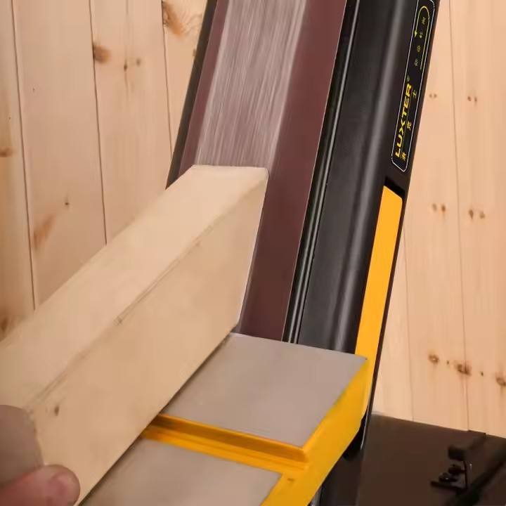 Bench belt sander sanding timber boards on the work table for woodworking and surface finishing
